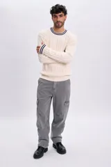 Pantalón de jean cargo recto color gris claro, de tiro medio, con bolsillos laterales con solapa en las piernas.