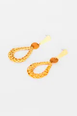 Aros colgantes con forma de lágrima hechos de mimbre color beige, con aplique circular de cuero marrón y pieza superior triangular dorada.