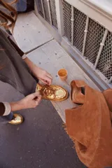 Championes negros de cuero con apliques metálicos plateados y suela color caramelo.