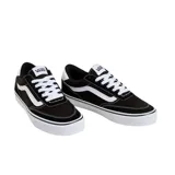 Championes Vans modelo Brooklyn LS, de diseño minimalista en color negro con detalles en blanco. Presentan la icónica franja lateral de la marca, cordones blancos y suela de goma vulcanizada con refuerzo en la puntera.