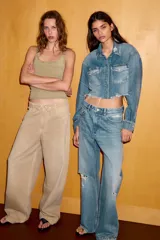 Jeans de corte boyfriend y tiro medio, con diseño de cinco bolsillos, cierre frontal con cremallera y botón metálico. Presenta un acabado lavado con detalles de roturas y desgastes.