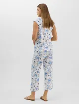 Pijama compuesto por remera sin mangas con escote redondo, botones frontales y detalle de puntilla, acompañado de un pantalón capri con cintura elástica. Presenta un estampado floral en tonos rosados sobre base gris.