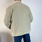 Chaqueta de pana color beige con forro de corderito en el cuello y el interior. Tiene cierre con botones, bolsillos en el pecho y bolsillos laterales.