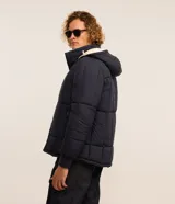 Campera puffer de hombre reversible, con diseño acolchado, cuello alto, capucha y cierre frontal.