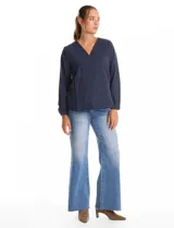 Blusa de algodón azul marino con bordado floral al tono. Presenta escote en V con terminación festoneada y mangas largas ligeramente abullonadas con puños abotonados. Su diseño es de silueta fluida y relajada.