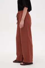 Pantalón de algodón color terracota, de tiro alto y calce holgado, con cintura elástica con cordón ajustable y bolsillos frontales aplicados.