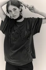 Remera de algodón y modal con cuello redondo, mangas cortas con detalle de rayas laterales y estampa frontal con la palabra LOVE bordada en lentejuelas.