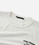 Remera de manga larga Blue Steel, confeccionada en tejido texturizado de poliéster con elastano. Presenta cuello redondo y estampa frontal con la frase 'Stay Classic'.