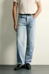 Jeans de corte recto en tono azul clásico con efecto lavado, tiro medio y diseño de cinco bolsillos con cierre frontal de botones.