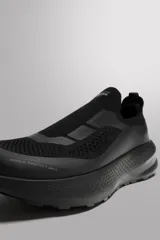 Zapatilla deportiva negra sin cordones para uso diario y carreras ligeras. Parte superior de tejido de punto transpirable, puntera y talón recubiertos de material Shield Protect Max, tirador trasero, plantilla OrthoLite® extraíble, entresuela con tecnología Spume Foam V3 y suela de goma. Zara Athleticz.