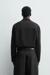 Camisa de corte relajado confeccionada en tejido mezcla de viscosa, con cuello solapa, cierre frontal de tres botones y manga larga con puños abotonados.