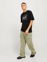 Pantalón cargo de corte amplio y tiro medio, confeccionado en tejido de sarga resistente. Presenta bolsillos laterales tipo cargo, bolsillos delanteros y traseros, con cierre de cremallera.