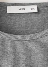Musculosa de canalé confeccionada en mezcla de algodón, viscosa y elastano. Presenta diseño entallado, corte recto y cuello redondo.