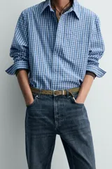 Cinturón de piel con acabado serraje (efecto gamuza) color verde oliva. Presenta hebilla metálica plateada de forma rectangular y puntera acabada con una chapa metálica plateada de estilo western.