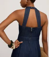 Vestido midi de jeans azul, con frente única, sin mangas y espalda descubierta.