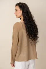 Sweater de tejido semitransparente color marrón con brillo dorado, cuello bote y mangas largas de corte holgado.