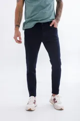 Pantalón de jean azul oscuro, corte skinny, tiro medio y cinco bolsillos.