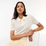 Remera de punto calado de manga corta en color blanco, con cuello polo y cierre frontal de botones.