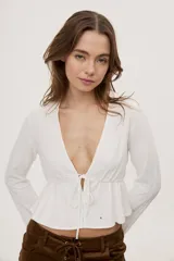 Blusa manga larga de color negro con escote en V profundo y lazo ajustable en el frente, confeccionada en tejido liviano con corte evasé.
