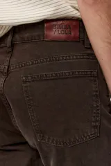 Pantalón de denim color marrón oscuro, tiro medio, corte ajustado y diseño de cinco bolsillos.