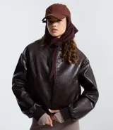 Campera bomber femenina de cuero sintético color marrón oscuro, con cuello alto, frisos en los hombros, puños y bajo ajustados, y cierre delantero con cremallera.