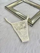 Pack de tres microtangas de encaje con diseño floral, cuentan con tiras laterales regulables y bordes con terminación en cinta elástica. El set incluye una prenda negra, una blanca con estampado floral negro y una beige con estampado floral negro.