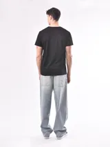 Remera negra de algodón con estampado abstracto en tonos rosa y gris.