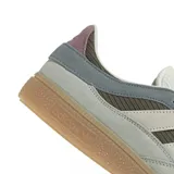 Championes Adidas Handball Spezial con diseño retro, confeccionados en una combinación de gamuza y tejido acanalado. Presentan una paleta de colores en tonos oliva, gris y crema, con las icónicas tres bandas laterales en blanco y suela de goma color caramelo.