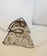 Collar con colgante de plata 950 con forma de crismón, que simboliza el nombre de Cristo en lengua griega. El colgante mide 2,7 cm x 1,1 cm y el largo del cuero es de 85 cm.