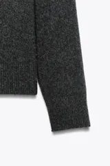 Jersey de punto de cuello redondo y manga larga, con acabados en rib en puños, cuello y bajo.