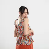 Blusa negra con estampado de flores celestes y hojas verdes, con breteles finos con volados.