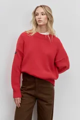 Sweater de punto en color beige, con cuello redondo acanalado, mangas largas con puños ajustados y diseño holgado.