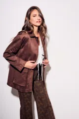 Campera estilo chaqueta marrón oscuro con cuello solapa, cierre frontal con botones oscuros y bolsillos de parche en la parte delantera.