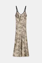 Vestido midi de estilo lencero con estampado animal print, confeccionado en tejido satinado. Presenta escote en pico tanto en el delantero como en la espalda y cuenta con doble tirante fino en color negro.