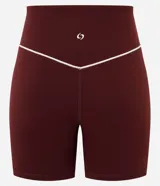 Bermuda deportiva femenina de tiro alto en color bordó, con calce ajustado y líneas contrastantes en los laterales.