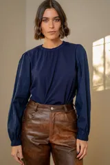 Remera de algodón azul marino con mangas largas abullonadas de tela texturizada y puños elásticos. Presenta cuello redondo con detalle de frunce.