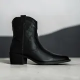 Bota estilo texana de caña media, color negro, con costuras decorativas en el lateral y taco cuadrado.