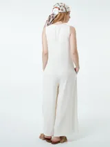 Mono largo color crudo, con botones en la parte delantera, bolsillos laterales ocultos y corte palazzo.