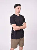 Remera negra de manga corta con cuello redondo y bolsillo en el pecho. Presenta un sutil patrón de rayas horizontales en el tejido.