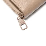 Billetera de tamaño mediano confeccionada en material símil cuero con textura granulada. Presenta un cierre perimetral y una solapa frontal con broche a presión decorada con una flor en relieve y el logo metálico de la marca.