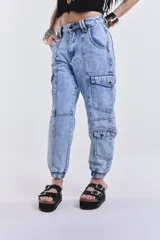 Pantalón cargo de denim estilo babucha, color celeste lavado, con múltiples bolsillos utilitarios en los laterales y puños elásticos en los tobillos.