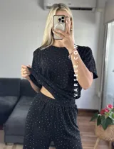 Conjunto negro con pequeños lunares dorados, compuesto por una remera de mangas cortas y un pantalón palazzo con cintura elastizada.