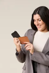 Tarjetero minimalista de ecocuero color marrón y negro, con cierre superior y ranuras externas.