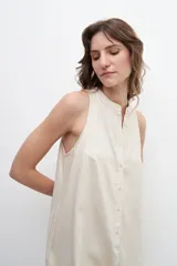 Mono corto de lino color beige, con escote mao y cierre frontal con botones.