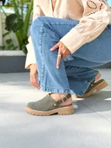 Zuecos de cuero color verde seco, con hebilla lateral y suela de goma.