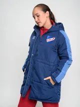 Parka larga de abrigo Umbro del Club Nacional de Football, color rojo con detalles en naranja en las mangas. Cuenta con capucha, cierre frontal con botones a presión y escudo del club bordado en el pecho.