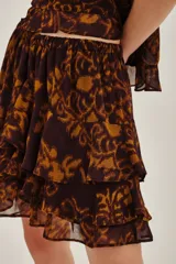 Falda corta con volados, confeccionada en tela estampada con diseño abstracto en tonos marrones y ocres.
