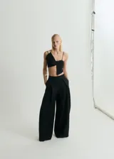 Top negro con tirantes finos, diseño crop y lazo en el frente.