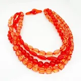 Collar de varias vueltas con cuentas de resina translúcida color rojo y naranja, con diferentes formas y tamaños.