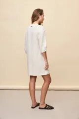 Vestido corto negro de silueta relajada, con escote en V y mangas 3/4 levemente abullonadas.